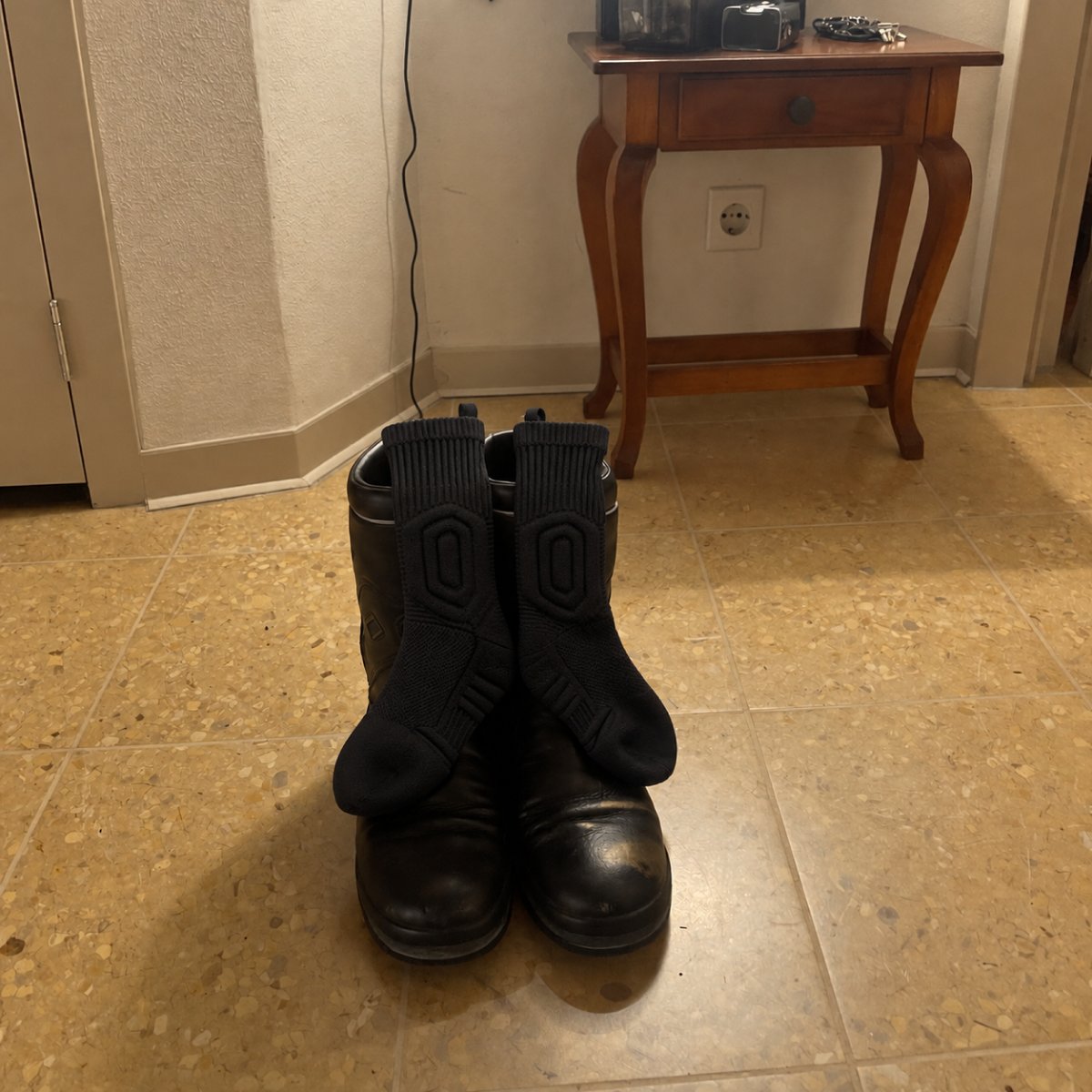 Calcetines Talón Firme y botas de trabajo en el pasillo de una casa española